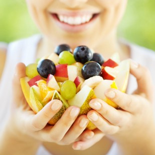 Photo: Woman Smiling and Holding a Fruit Bowl