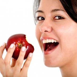 Photo: Woman Smiling and Eating an Apple