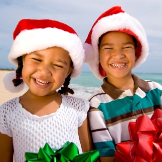 Photo: Boy and Girl holding Christmas Gifts on the Beach