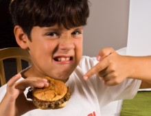 Photo: Boy Frowning and Holding a Burger