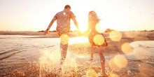 Photo: Couple Holding Hands and Running on the Beach